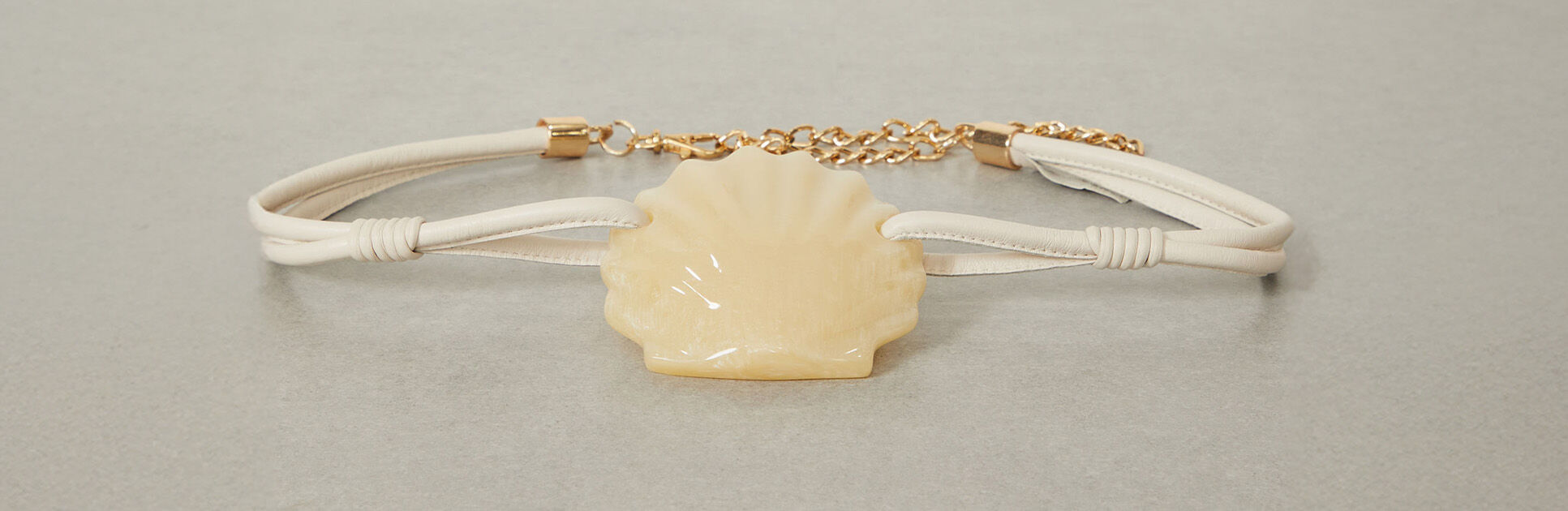 Bracelete com detalhe de concha creme e corrente dourada