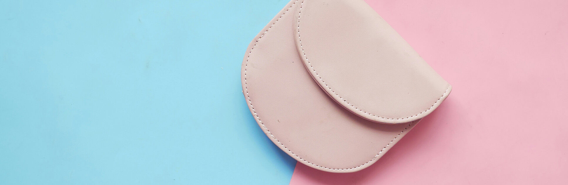 Carteira rosa sobre fundo azul e rosa