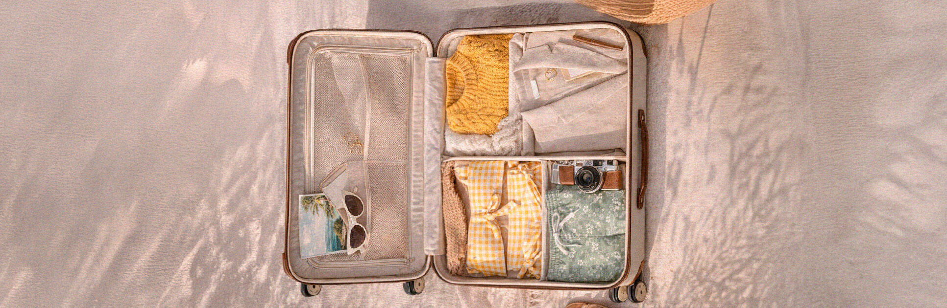 Mala de viagem aberta com roupas e acessórios organizados