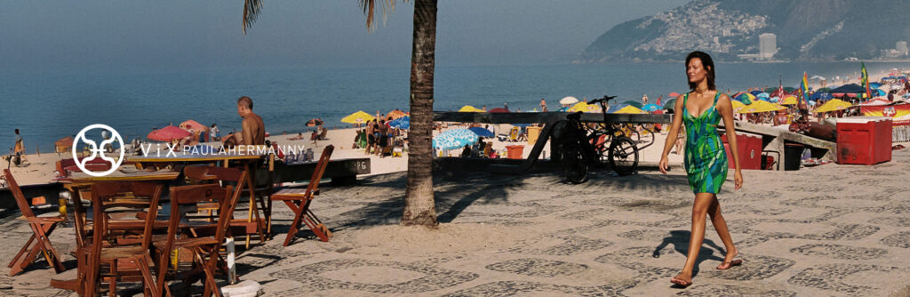 Mulher caminhando na praia com estrutura de quiosques