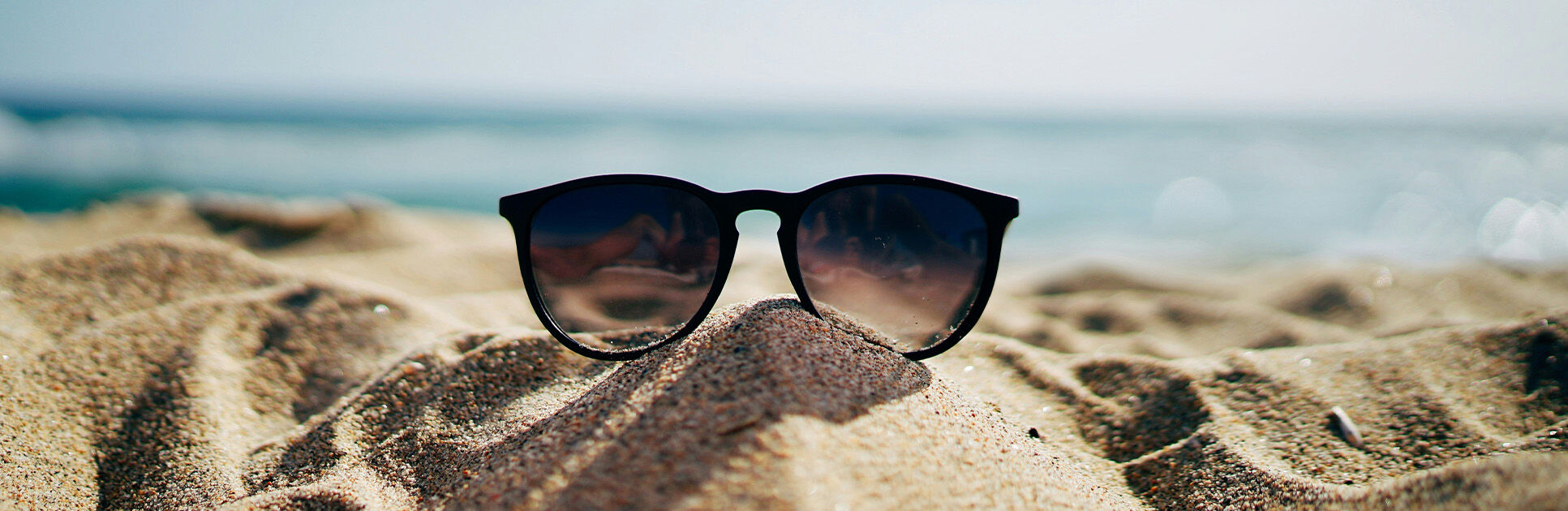 Óculos de sol sobre a areia da praia