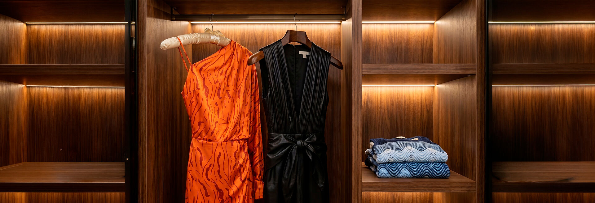 Roupas elegantes em um closet iluminado