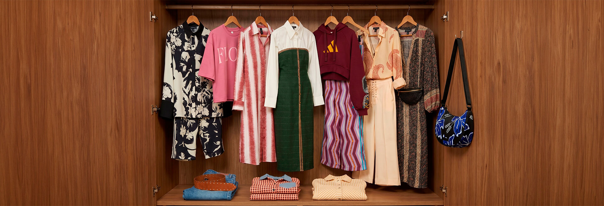 Roupas variadas organizadas em um armário de madeira